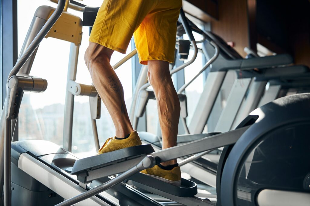 Caucasian sportsman training on the elliptical trainer