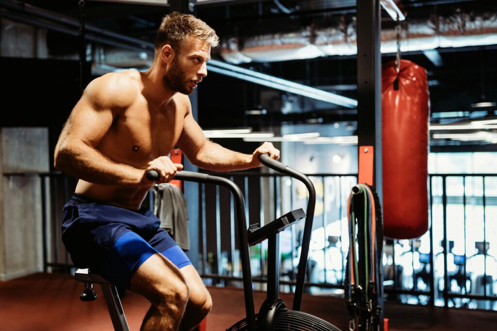 Man with weight training equipment exercising in sport gym club